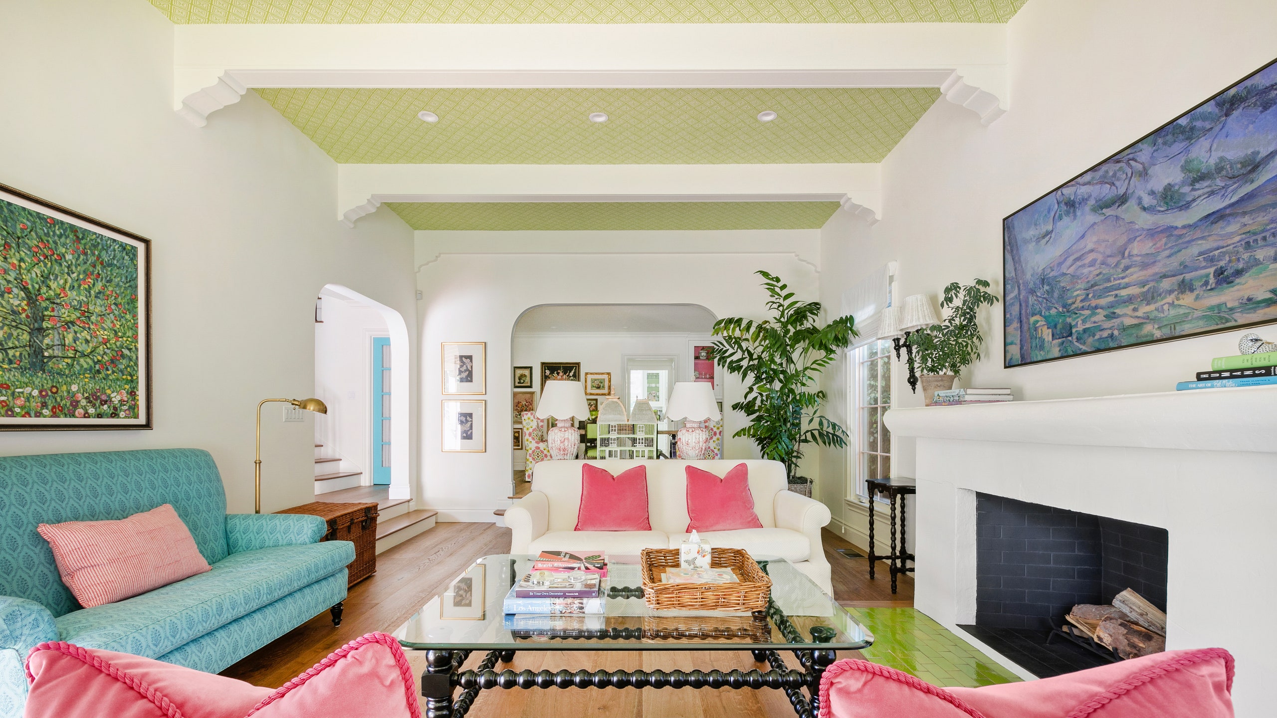 Emma Stones LA home living room with two white sofas opposite each other blue sofa to left beamed ceilings white walls...