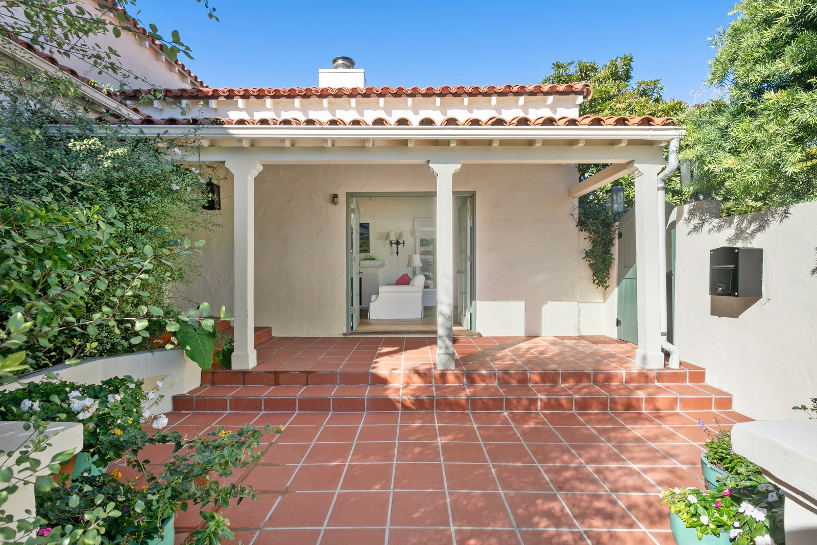 White columns red tiled roof greenery