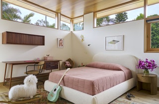 Pink bedding on white bed frame light green and white guitar leaning against bed floating cabinet above desk lamb...