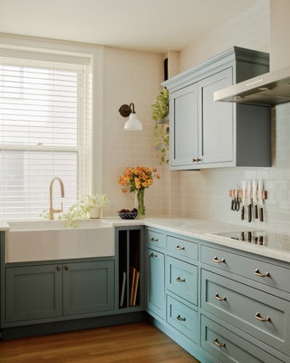 The part of the kitchen dedicated to meal prep and cooking holds a ceramic apronfront farm sink and a Gaggenau cooktop.