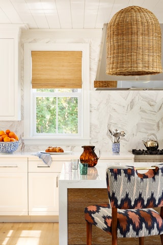 In the kitchen Okin introduced a hint of coral on the Wyatt chairs from Anthropologie a nod to the Internationalorange...