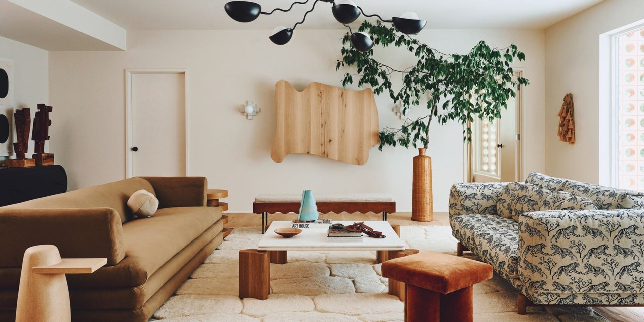 chic living room with velvet sofa and wavy pendant lamp and large planter with greenery