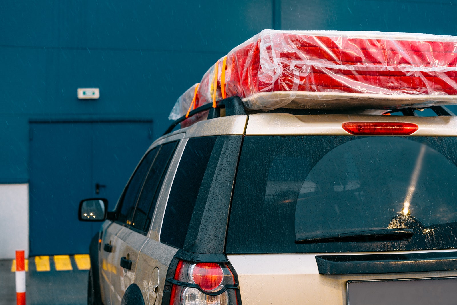 Wrapped mattress atop car for transport