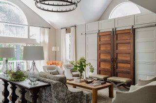 This living rooms white walls got a major upgrade in the form of a barn door which adds visual interest to the space...