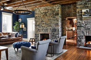 Designed by BallardMensua Architecture in Washington DC this living room features bold blue walls paired with a mostly...